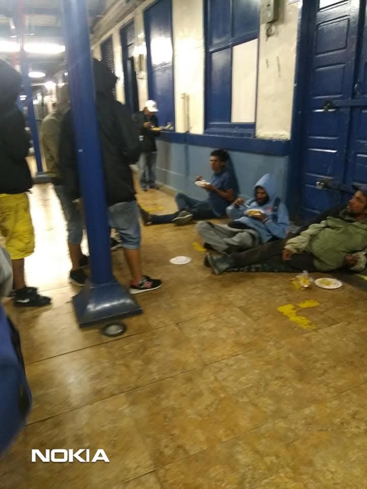 Personas en calle recibiendo comida